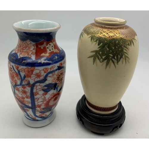 368 - Two Oriental vases and a wooden stand 9.5cms h and 10.5cms h.