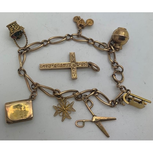 693 - A 9ct charm bracelet and 7 charms and a 9ct gold crucifix. 18gms total weight.