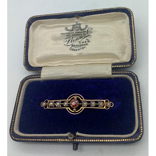 702 - A 9ct gold bar brooch set with eight seed pearls and a central red stone in original silk lined box.... 