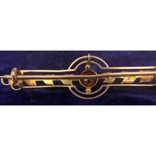 702 - A 9ct gold bar brooch set with eight seed pearls and a central red stone in original silk lined box.... 