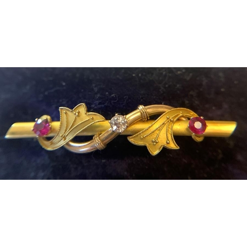 703 - A 15ct gold bar brooch set with central diamond flanked by red stones to each side in original fitte... 