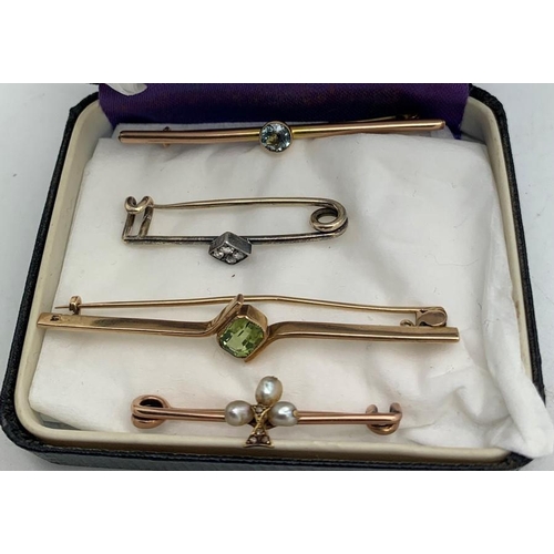 708 - Four early 20thC tie pins to include one set with pale blue stone marked 9ct, one with green stone m... 