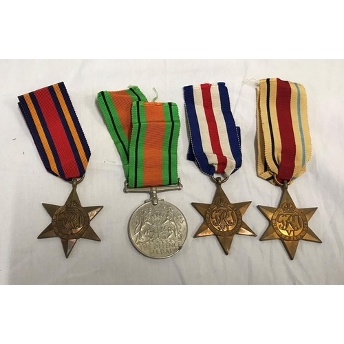 775 - WW II group of four medals. Defence, Africa, France and Germany and Burma star medals with ribbons.