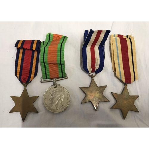 775 - WW II group of four medals. Defence, Africa, France and Germany and Burma star medals with ribbons.