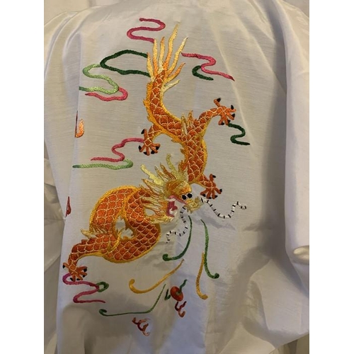 94 - A Chinese embroidered dressing gown and a red embroidered wrap top from Hong Kong.