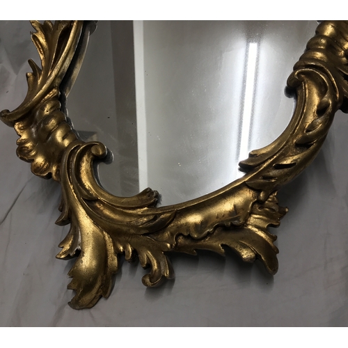 1156 - Decorative gilt framed wall mirror, scroll leaf design. Frame size approx. 82 h x 39cms w.