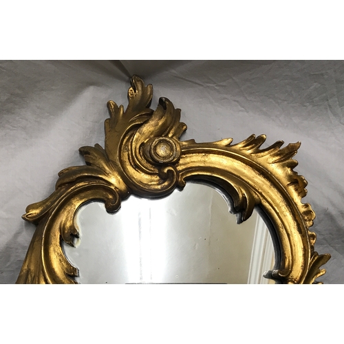 1156 - Decorative gilt framed wall mirror, scroll leaf design. Frame size approx. 82 h x 39cms w.