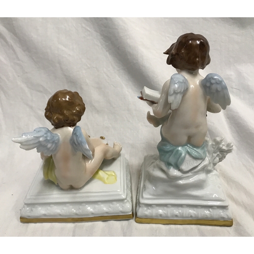 255B - Two Scheibe Albach porcelain figurines. Cherubs, one sat on a plinth painting in a book 15cms h and ... 