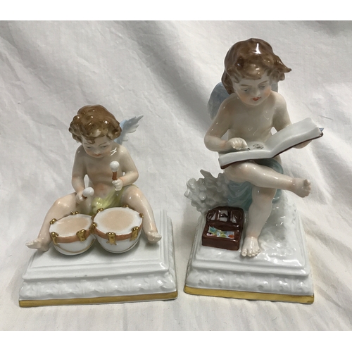 255B - Two Scheibe Albach porcelain figurines. Cherubs, one sat on a plinth painting in a book 15cms h and ... 