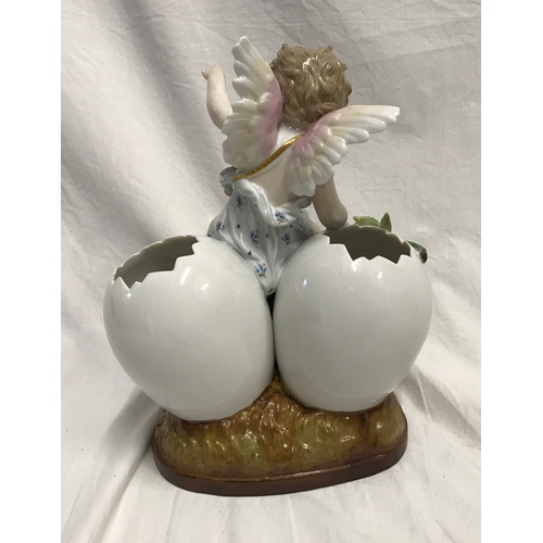 255C - A KPM porcelain figurine cherub sat on three hatched eggs with floral decoration 14cms h x 18cms w.