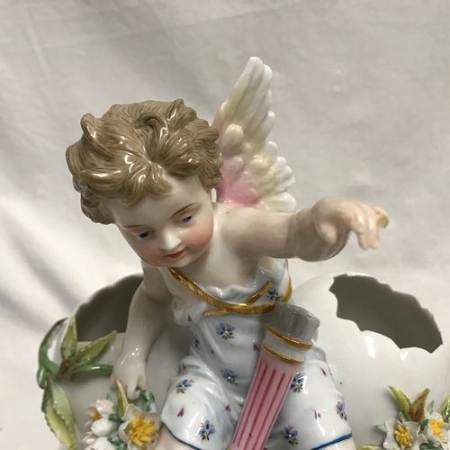 255C - A KPM porcelain figurine cherub sat on three hatched eggs with floral decoration 14cms h x 18cms w.