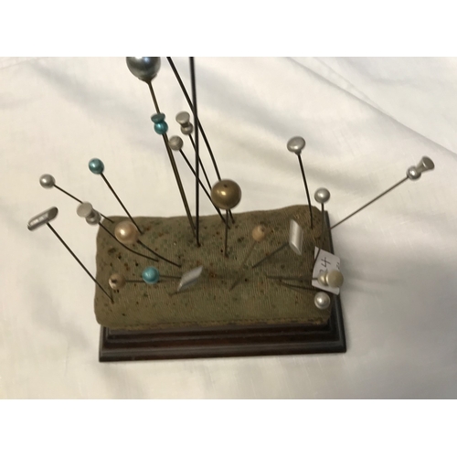 724 - Hat pin cushion stand with a collection of 39 various hat pins including inlaid two silver tortoises... 