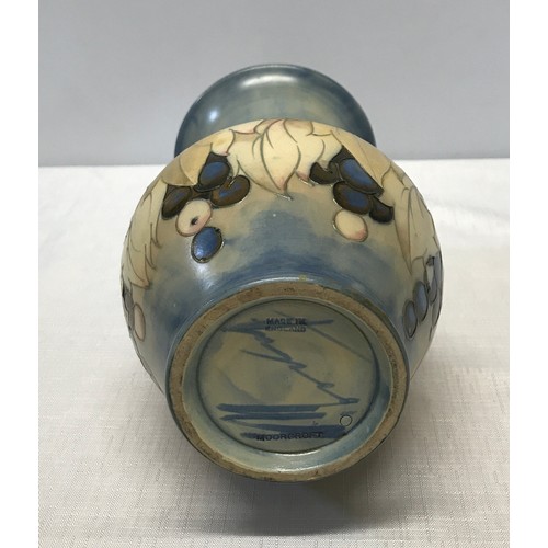 27 - A Moorcroft leaves and berries design long vase with light blue signature and mark to bottom, made i... 