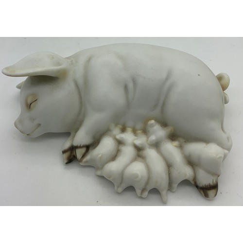 56 - A ceramic recumbent pig suckling piglets. 15cms l.