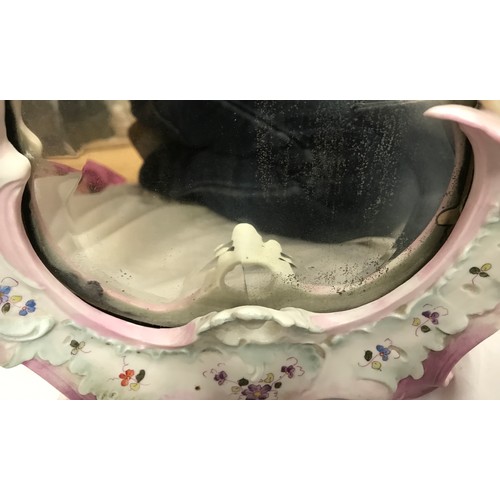 59 - A decorative porcelain framed toilet mirror with floral design and mounted with cherubs 36cm h x 23c... 