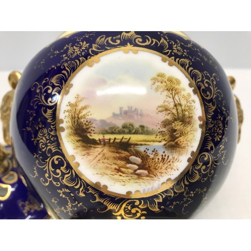 119 - A Coalport signed blue ground and gilt lidded vase with a painted panel of a country scene near Dove... 