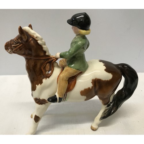 148 - A Beswick Huntsgirl on a skewbald pony. Approx. 14cms h x 15cms l.