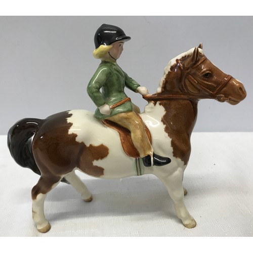 148 - A Beswick Huntsgirl on a skewbald pony. Approx. 14cms h x 15cms l.