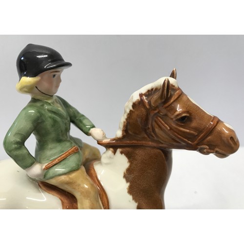 148 - A Beswick Huntsgirl on a skewbald pony. Approx. 14cms h x 15cms l.