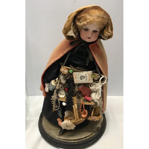 208 - A good example of a Victorian pedlar doll on a circular ebonised base under a glass dome. Doll with ... 