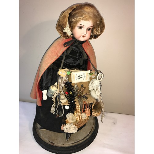 208 - A good example of a Victorian pedlar doll on a circular ebonised base under a glass dome. Doll with ... 