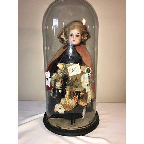 208 - A good example of a Victorian pedlar doll on a circular ebonised base under a glass dome. Doll with ... 