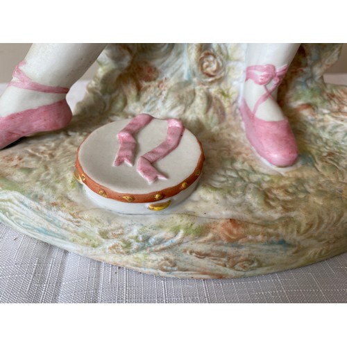 215 - A continental figurine of a young girl in a pink dress and ballet shoes with a tambourine. 40cms h  ... 