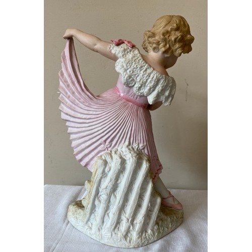 215 - A continental figurine of a young girl in a pink dress and ballet shoes with a tambourine. 40cms h  ... 