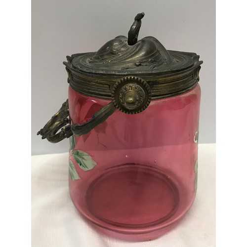 260 - A Victorian cranberry glass biscuit barrel with painted floral design and brass spelter top and hand... 