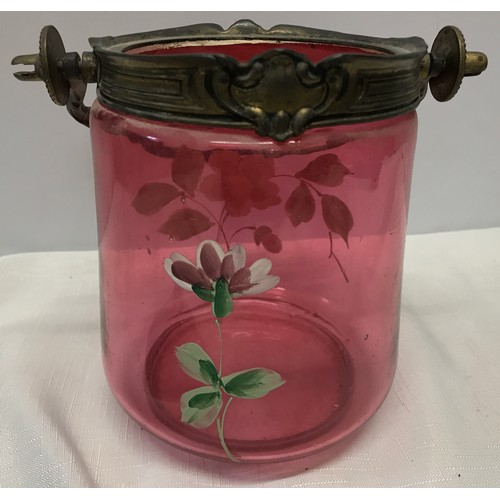 260 - A Victorian cranberry glass biscuit barrel with painted floral design and brass spelter top and hand... 