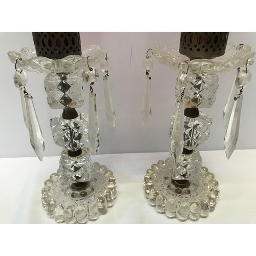 265 - A pair of glass candlesticks with cranberry coloured shades engraved with a leaf decoration. 13cm h ... 