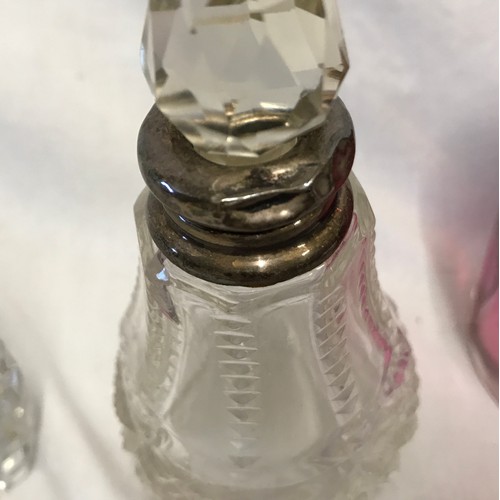 266 - Three glass scent bottles to include one cranberry coloured 12cm h with sterling silver rim, one cle... 