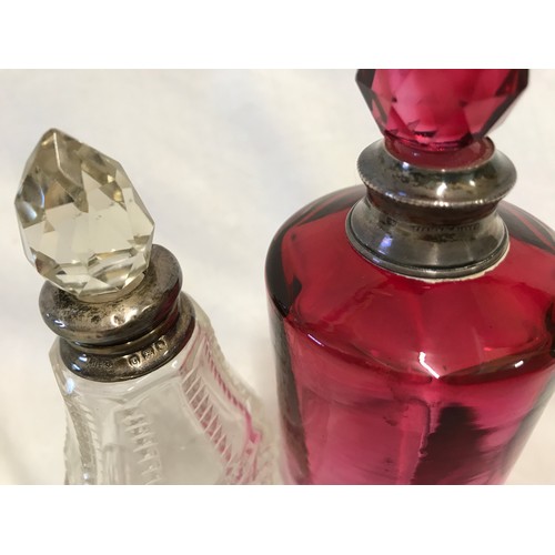 266 - Three glass scent bottles to include one cranberry coloured 12cm h with sterling silver rim, one cle... 