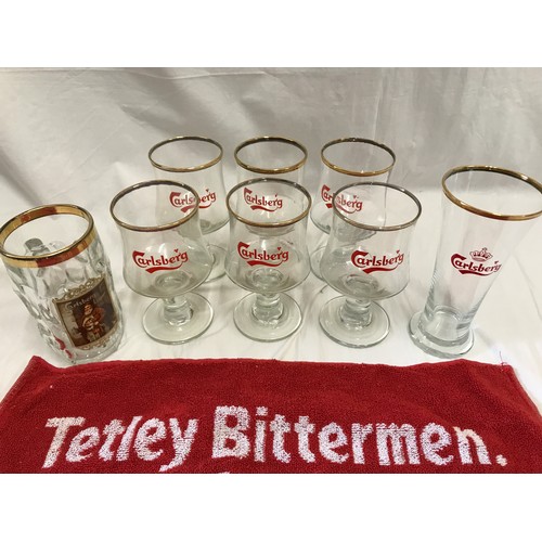 284 - A selection of Carlsberg drinking glasses together with two Tetley Bittermen bar towels.