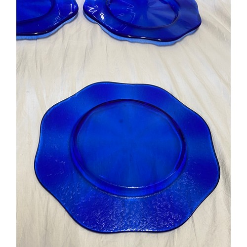 286 - A set of eight good quality heavy cobalt blue glass charger plates, with a scalloped edge and a text... 