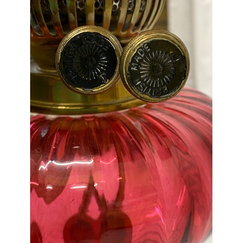 288 - A 19thC cranberry glass oil lamp with cranberry and white glass shade, Corinthian brass column and s... 