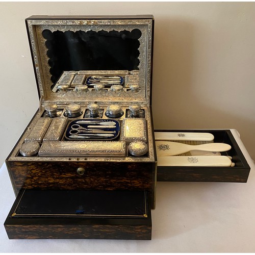 A fine quality Victorian coromandel wood dressing case with eleven extensively engraved silver topped glass jars and containers all London 1864 maker probably William Neal. Crested with engraved initials. Two secret drawers, a side one with ivory brushes by Asprey 166 Bond Street, the other lower front silk lined for jewellery. Fold down removable mirror with a spring release to reveal secret document pouch and makers stamp W H Tooke of Liverpool.
 33.5cms l x 21cms h x 25.5cms d.