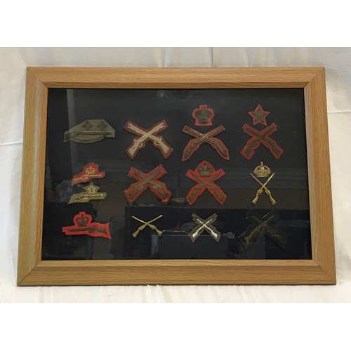 897 - A framed and mounted early 20th century military marksman crossed rifles patches and badges,frame si... 