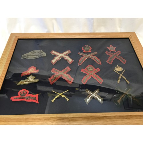 897 - A framed and mounted early 20th century military marksman crossed rifles patches and badges,frame si... 