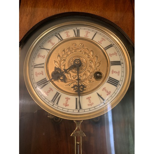 923 - A 19thC mahogany Vienna wall clock with brass and enamel dial and pendulum. 99cms h x 35cms w.