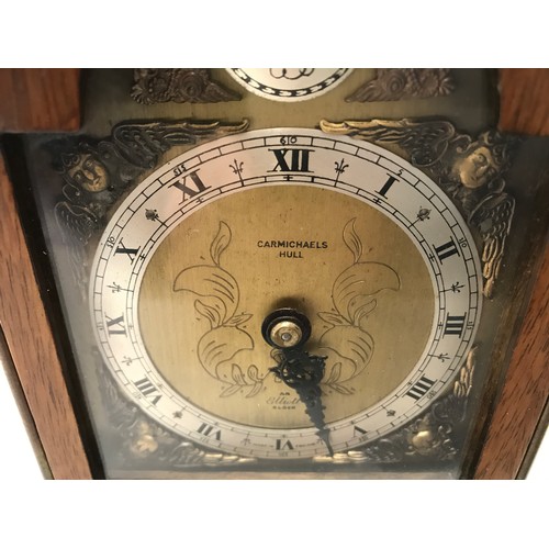 929 - A mahogany cased Elliot mantle clock with a cherub decorated brass face. Retailed by Carmichaels of ... 