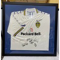 A framed Leeds United football shirt with signatures to include Lucas Radebe and others.