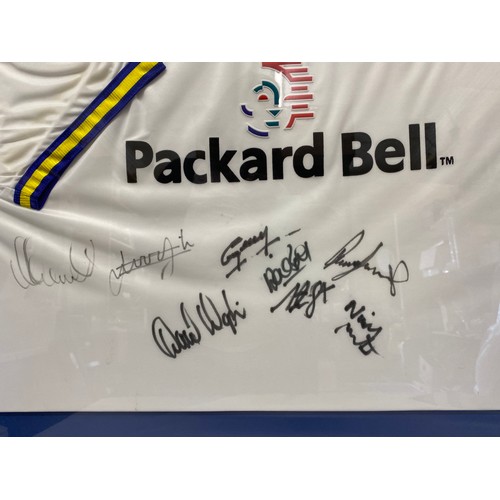 938 - A framed Leeds United football shirt with signatures to include Lucas Radebe and others.