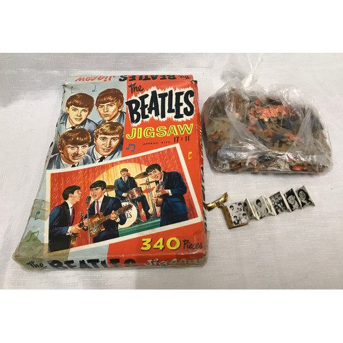 948 - The Beatles, 340 piece jigsaw puzzle and a novelty brooch of book form with pull out portfolio photo... 