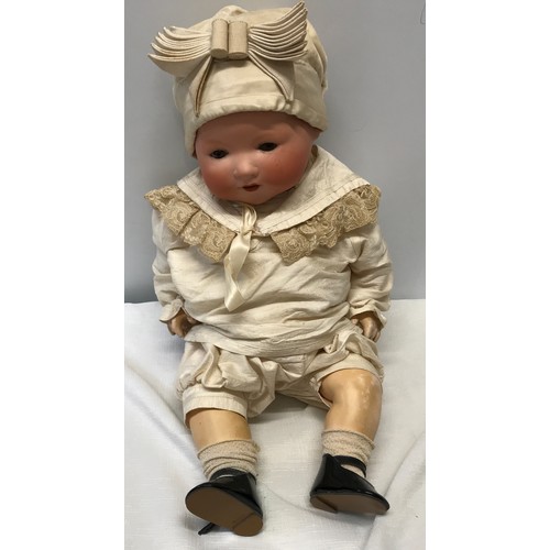 977 - An A.M. Germany pot headed doll with composite body, open/close eyes approx 53cm h. Stamped to the b... 