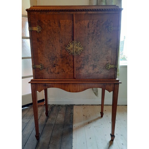 1486 - A burr walnut drinks cabinet with pull out shelf and revolving circular drinks holder to interior, w... 