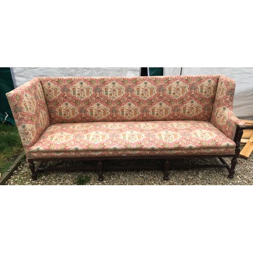 1503 - A mahogany framed floral upholstered wing back sofa. 200 w x 65 d x 90cms h.