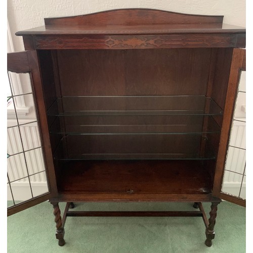 1511 - An oak 2 door display cabinet with leaded clear and coloured glass doors on barley twist legs.