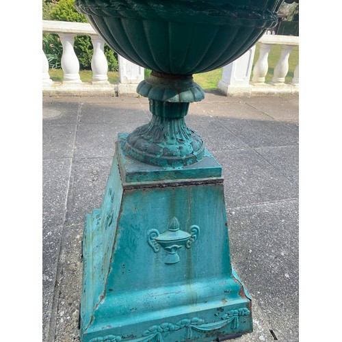 1527 - A 19thC cast iron urn on a stand. 48 x 48cms base, 84cms h , top 53cms d