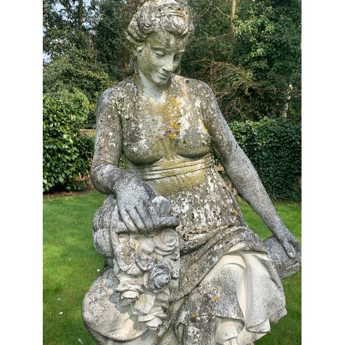 1531 - A reconstituted stone garden ornament of a female figure with flower basket seated on tree stump and... 